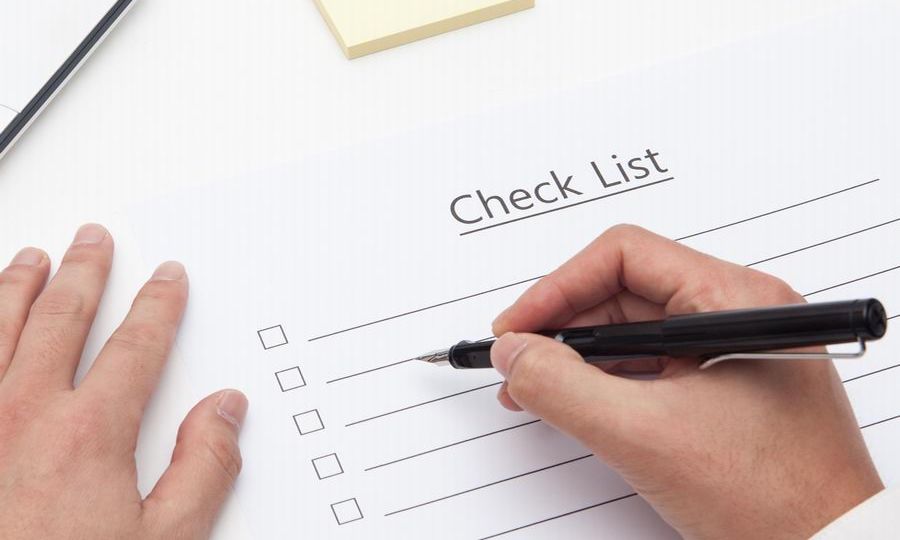 Canva - businessman write on checklist with pencil in office